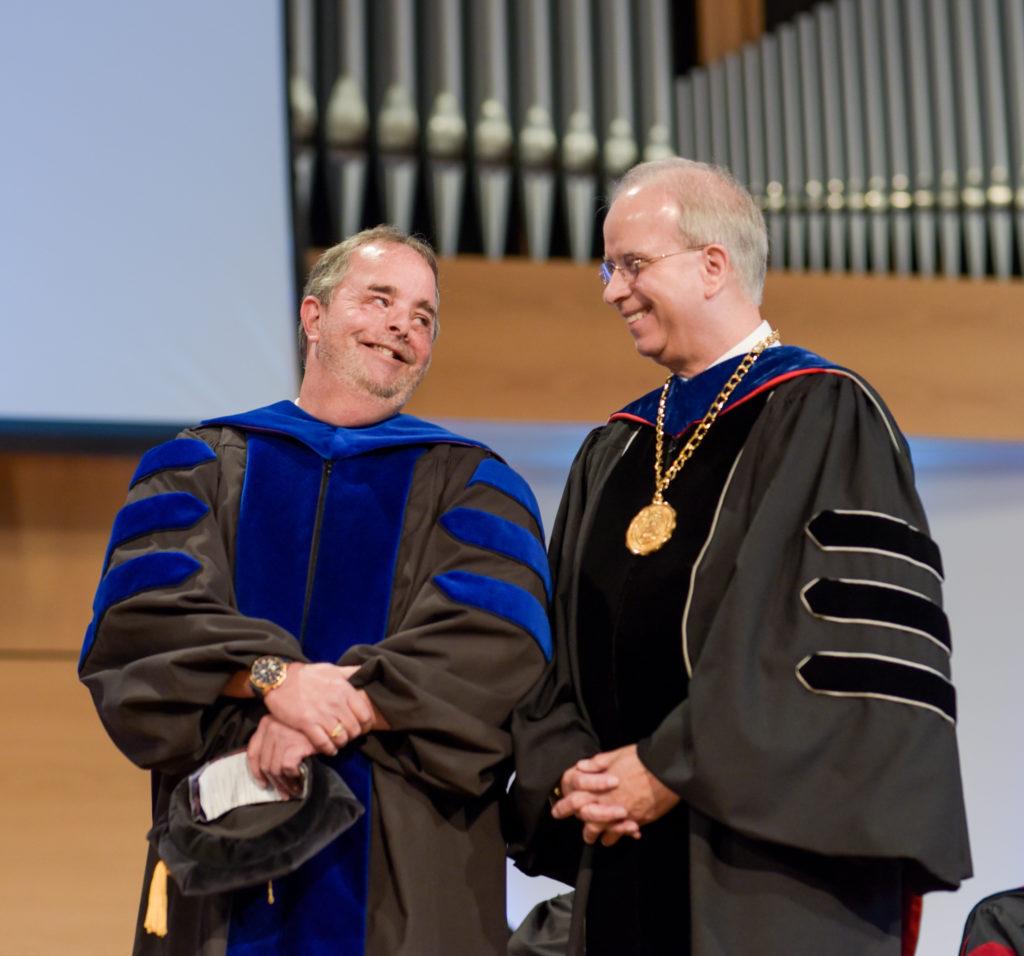 Dr. Chuck Crain smiles with Dr. Michael V. Carter, during the opening chapel convocation at Campbellsville University. (Campbellsville University Photo by Joshua Williams)