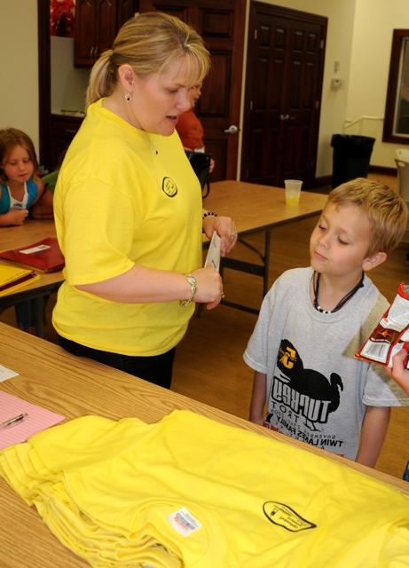 Kids College graduate Bode Copeland asked Director Carol Sullivan, &quot;So, aren' we supposed to have caps and gowns?&quot; After she explained that Kids College grads got yellow t-shirts instead, he asked, &quot;how did you know the right sizes to get?&quot; And after she answered that, Bode had more questions. Thats what Kids College encourages. (CU Photo by Linda Waggener)