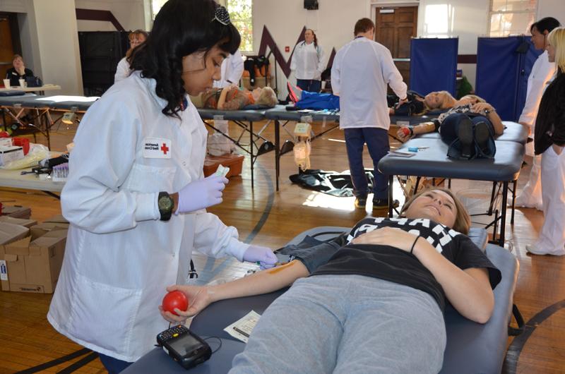 Bethany Gusler, a Campbellsville University senior from Sonora, Ky., donates blood at Campbellsville University Nov. 14. Jasmine Rowan with the American Red Cross prepares to take her blood. The university’s goal was 85 units, and 109 units were collected. The next blood drive on campus is Feb. 20, 2014. (Campbellsville University Photo by Bethany Thomaston)