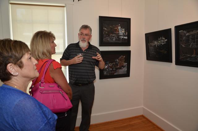 Bill Guffey, an artist from Burkesville in Cumberland County, Ky., explains his Google images to two of his art students, from left, Pattie Bryant of Burkesville, and Nancy Norris of Albany, during his opening reception. His work is on display at the Pence-Chowning Art Gallery through Sept. 12. (Campbellsville University Photo by Joan C. McKinney)