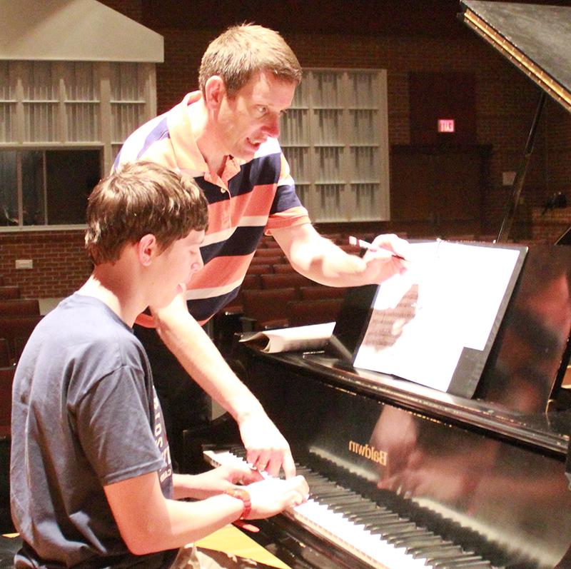 Dr. Bill Bubai, associate professor of piano studies, teaches a student piano during a one-on-one session. 