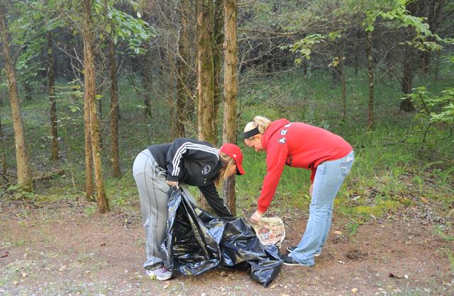 Cheerleaders, from left,  Amanda Alsbrooks, a sophomore from Corbin, Ky., and Shelly Dewar, a sophomore from Burlington, Ky., were part of 400 student/athletes who helped clean up Green River Lake Sept. 14. (Campbellsville University Photo by Courtney Drury)