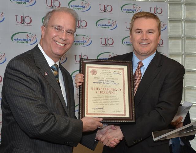 James Comer, left, Kentucky Department of Agriculture Commission, presents the Kentucky Proud Farm to Campus plaque to Dr. Michael V. Carter, president of Campbellsville University. CU is the  sixth university in the Commonwealth of Kentucky to join the program. (Campbellsville University Photo by Joan C. McKinney)