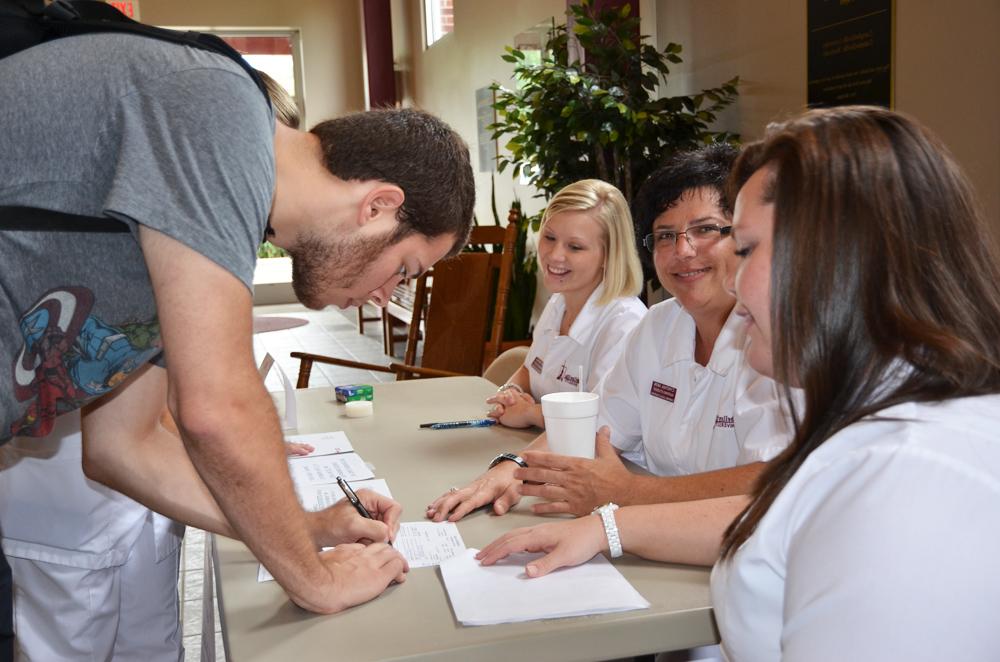 Michael Jennings signs up to have his blood donated to the American Red Cross. Student nurses Tonya Kessler, Cindy Akin and Carla Allen Mattingly, set up their booth in Winters Digning Hall during lunch hour to attract the most signatures. (Campbellsville University Photo by Ye Wei "Vicky")