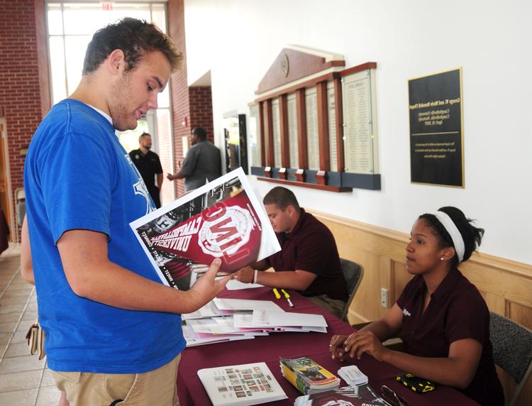 Michaela Parker, left, hands LINC information     to Drew O'Neil, an incoming freshman. (CU  Photo by Ellie McKinley)