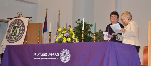 Dr. Beverly Ennis, left, and Dr. Carolyn Garrison, co-counselors for the chapter, look over the program for the initiation. (Campbellsville University Photo by Joan C. McKinney)