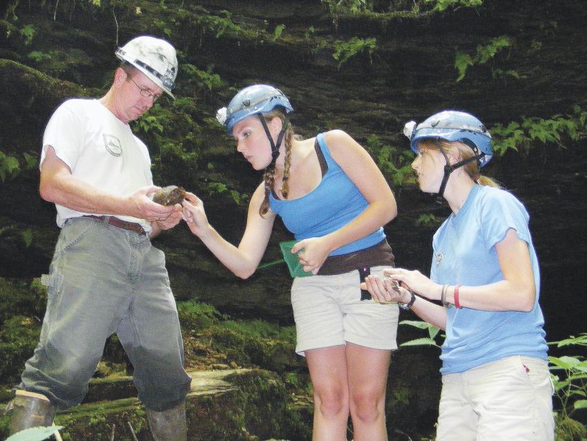 Environmental interns Amy Etherington, left, and Andrea O’Bryan study box turtles in Green County with U.S. Fish & Wildlife Biologist Chris Mason. (Photo by James Roberts, Central Kentucky News-Journal)