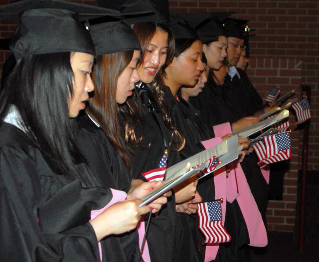 The graduates hold American flags while singing a hymn during the commencement ceremony. (Campbellsville University Photo by Joan C. McKinney)