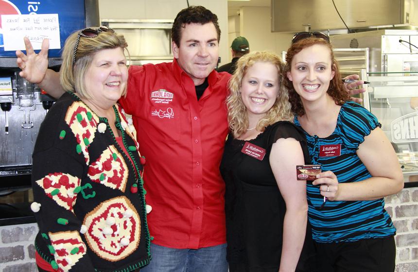 Kellie Vaughn and Kristin Davis, from left, and Pam Tennant, who was wearing a pizza sweater and pizza earrings, have their photo taken with "Papa" John Schnatter. (Campbellsville University Photo by Rachel DeCoursey)