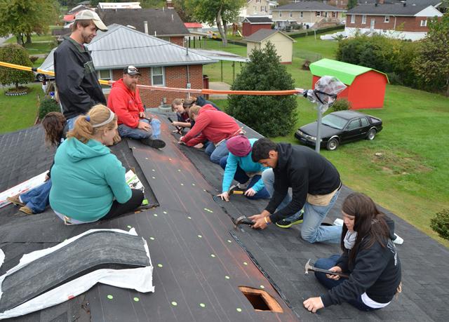 Trent Creason, standing, observes his FIRST CLASS small group as they work with Kentucky Heartland Outreach to repair a roof during Campbellsville University’s Repair Affair. (Campbellsville University Photo by Ashley Wilson)