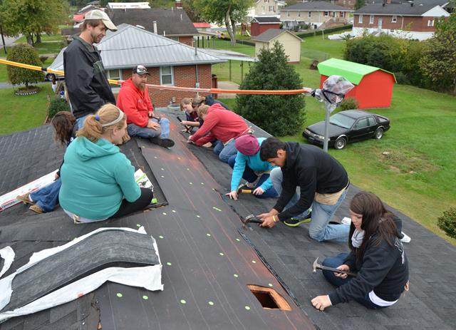 Trent Creason, standing, observes his FIRST CLASS small group as they work with Kentucky Heartland Outreach to repair a roof during Campbellsville University's Repair Affair. (Campbellsville University Photo by Ashley Wilson)