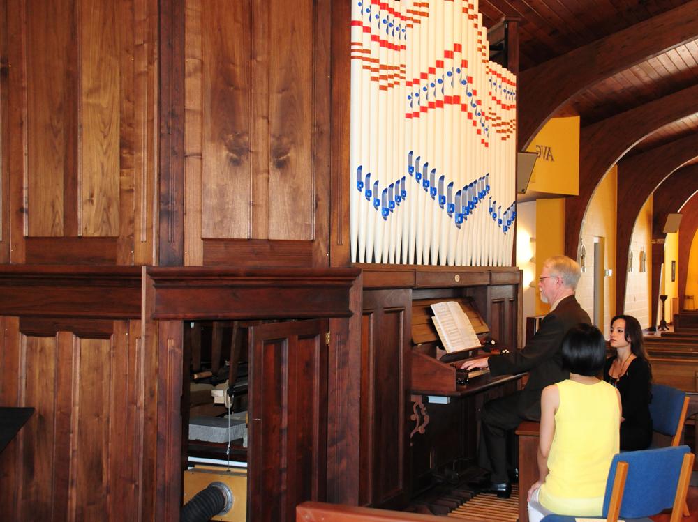 Dr. Wesley Roberts performs for the congregation at Our Lady of Perpetual Help Catholic Church at the dedication of the Pomplitz organ donated by Campbellsville University. Assistants Maria Milagros Boso Galli (left), Hsin-I Guo (center) and Jordan Hines helped with the performance. (Campbellsville University Photo by Drew Tucker)