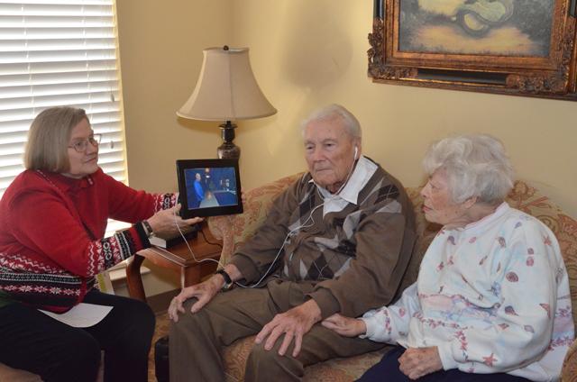 Dr. Ralph Tesseneer, center, a member of the Campbellsville University Board of Trustees, was given a digital photo frame with good wishes from the members of the CU Patrons of the Visual Arts to him for his support of the arts. Tesseneer is a member of the Patrons board. At left is his wife Laura and Linda J. Cundiff, chair of the department of art at CU, is holding the frame. The digital frame was the  idea of Jason England, assistant director of the Big Maroon Club at CU. (Campbellsville University Photo by Joan C. McKinney)