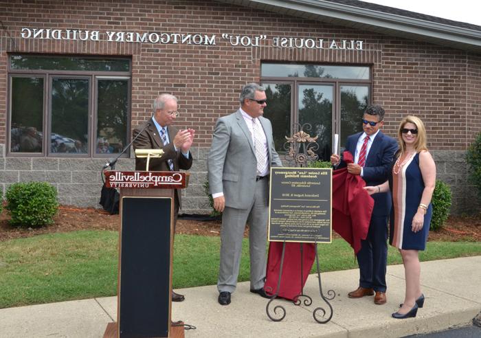 Dr. Michael V. Carter, president of Campbellsville University, applauds during the unveiling of the plaque naming of the Ella Louise “Lou” Montgomery academic building at the Louisville Education Center. From left are Stephanie Montgomery, Kris Mullins and Alex Montgomery, widower of Lou Montgomery. (Campbellsville University Photo by Joan C. McKinney) 