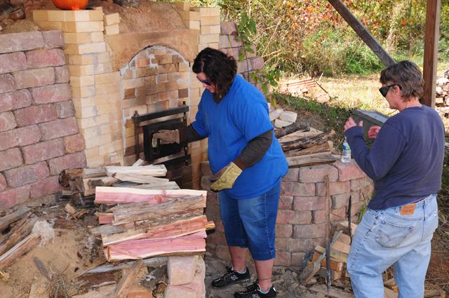 Davie Reneau, left, CU assistant professor of art, and Renee Renfro, a senior at Campbellsville University, work on the anagama kiln at Reneau's house in the fall. (Campbellsville University Photo by Lucas Pennington)