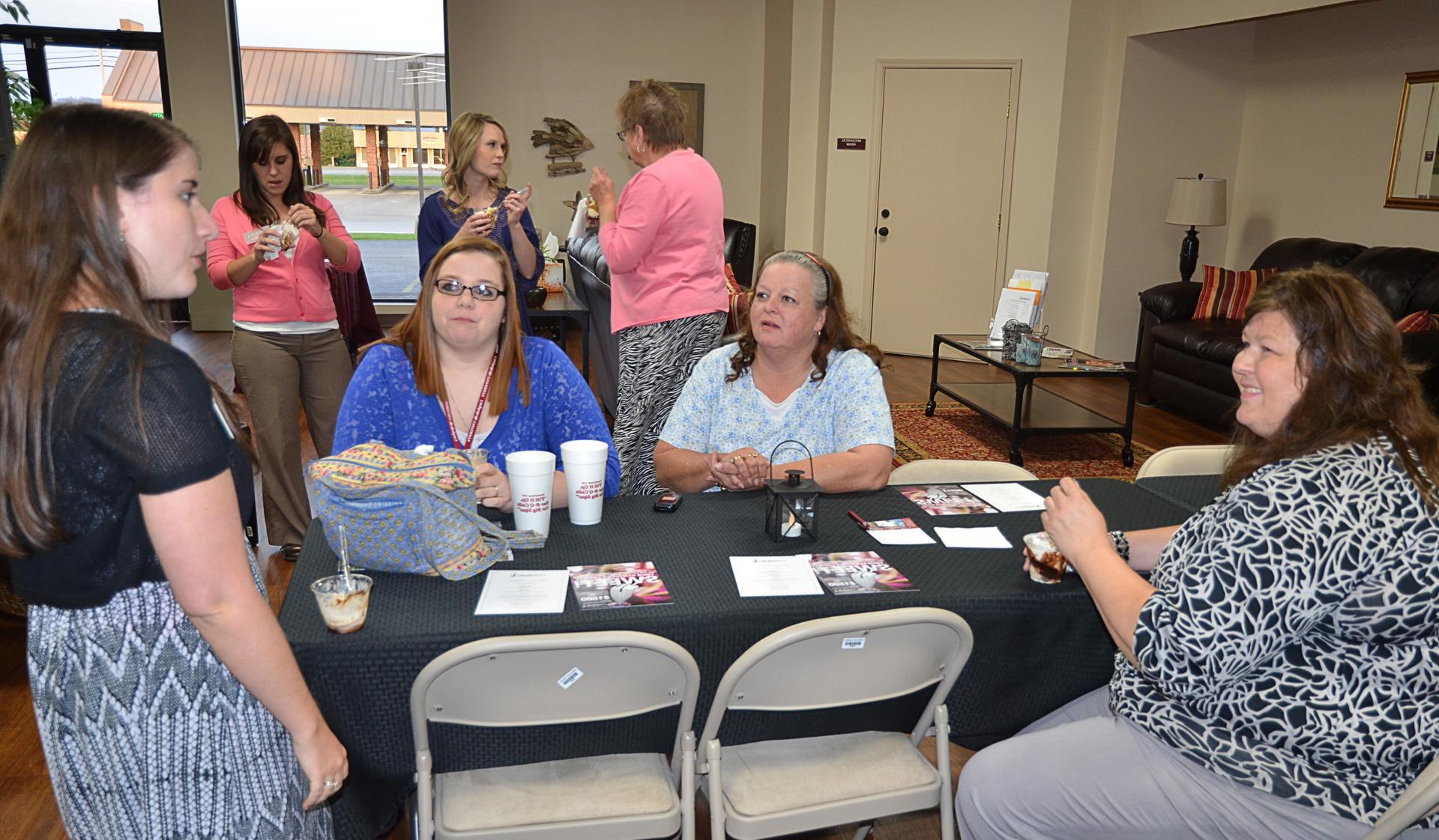 Admissions counselors Cindy Dishman and Katie Carpenter  discuss Campbellsville University with Margaret McGowen  and Larissa Miller. From left: Dishman, McGowan, Miller  and Carpenter. (Campbellsville University Photo by Drew  Tucker)