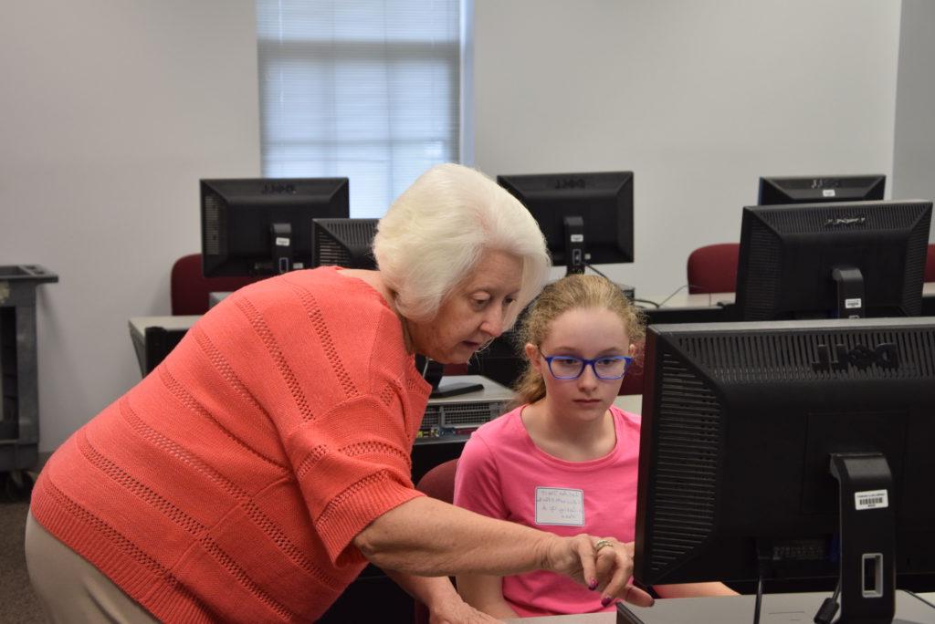 From left, LeeAnna Darst of Acton, Ky., gets instruction from Pat Hall in the Microsoft Office class offered during Kids College, a program that took place on Campbellsville University's campus. (Campbellsville University Photo by Ariel Emberton)