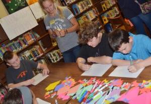 Toni Pfeifferm, CU student, helps CMS fourth-graders, from left, Mason Fisher, Zeke Harris and Kaleb Miller write their free verse poetry. (Campbellsville Independent School photo by  Calen McKinney)