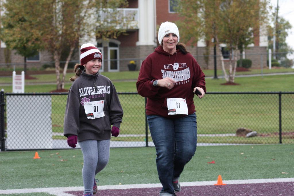 Sherry Peavler, and her daughter, Maddie, take part in the Alum Mile during 2017 Homecoming at Campbellsville University. Peavler is the wife of Darryl Peavler, director of alumni relations at Campbellsville University. (Campbellsville University Photo by Andrea Burnside)