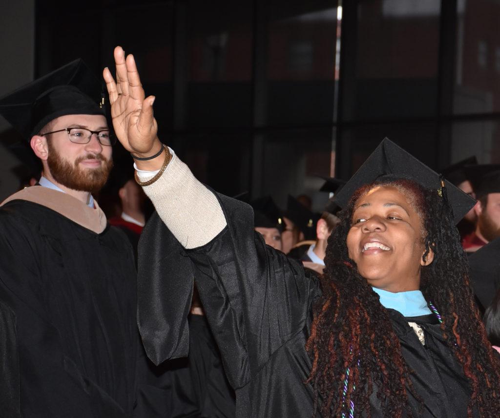 Gwendolyn Denise Atkinson-Sample of Louisville, Ky., waves at her family during the commencement at Campbellsville University. (Campbellsville University Photo by Ariel Emberton)