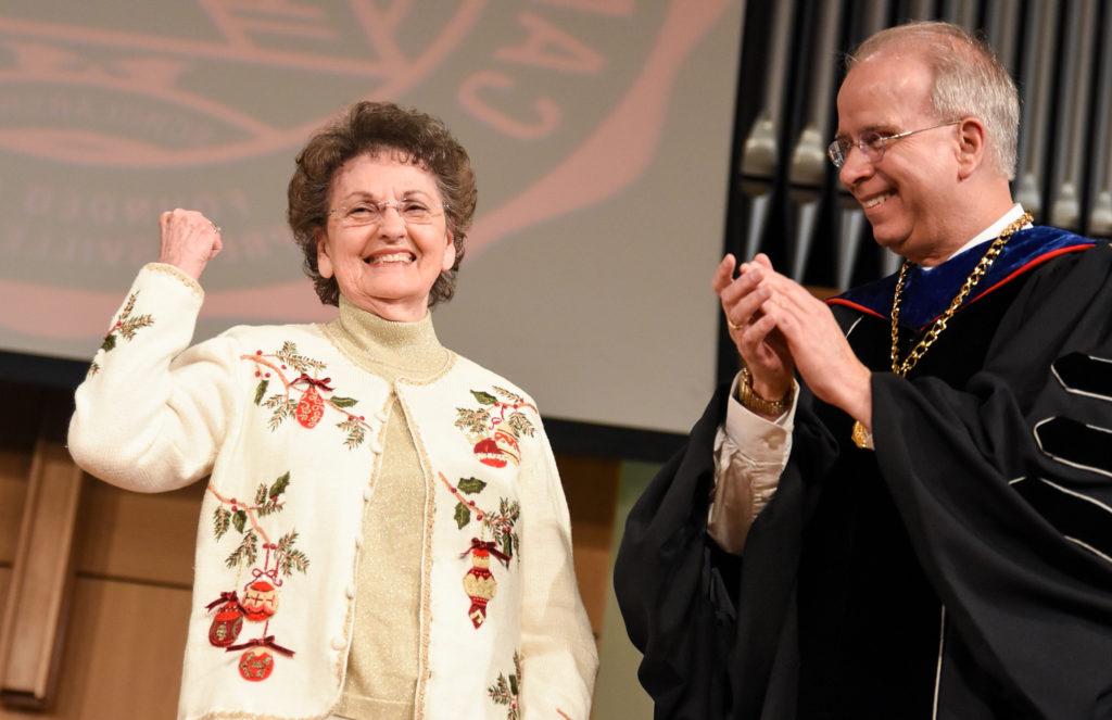 Jan Parrott Robinson of Burgin, Ky. celebrates after having been awarded her associate of science degree in social sciences – 60 years later after attending Campbellsville Junior College in 1956-58. At left is Campbellsville University president Dr. Michael V. Carter. (Campbellsville University Photo by Joshua Williams)